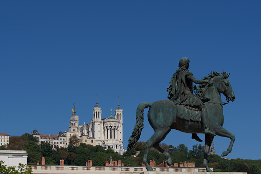 Statue of King Louis the 14th and in the background the Fourvière hill on which the Notre Dame de Fourvière basilica is placed in Lyon France