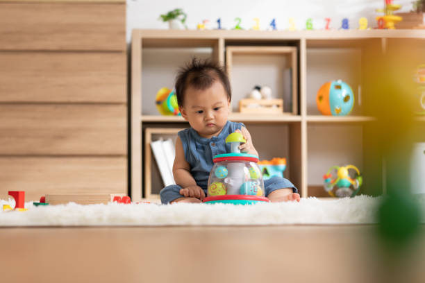 istock Cute Asian baby playing educational toys to learning and develop skill at home. Adorable cheerful baby toddler enjoy with toys in Nursery. Development skill in baby concept 1412009284