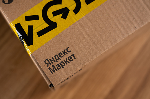 Moscow, Russia - 9 March 2022: Unopened online order box of Yandex Market marketplace with branded yellow tape