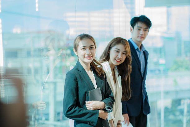 istock Young Asian business team working with laptops on financial documents with happy smiles. Group of business people meeting in a modern office Design and Concept Planning 1412012654