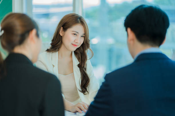 istock Young Asian business team working with laptops on financial documents with happy smiles. Group of business people meeting in a modern office Design and Concept Planning 1412013262
