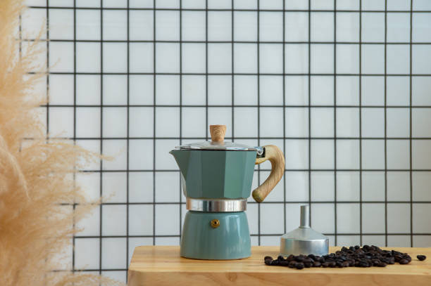 istock Coffee maker (Moka Pot), Moka pot on a wooden table next to coffee bean with whit background. 1412013432