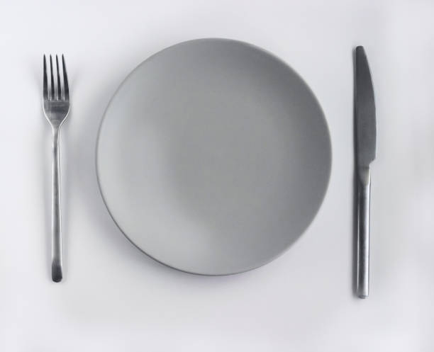 istock Grey empty plate with silver cutlery on the white table 1412017239