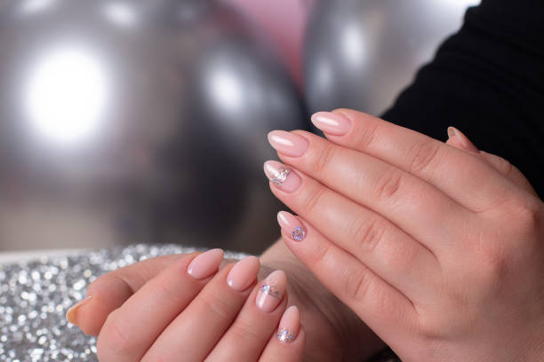 istock Female hands with romantic manicure nails, pink gel polish 1412021302