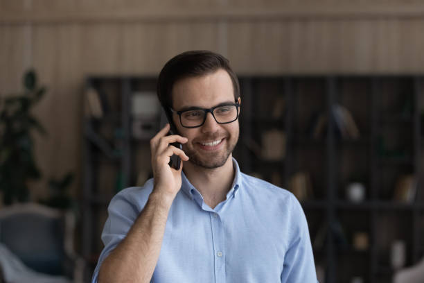 istock Head shot smiling man in glasses making phone call 1412021381