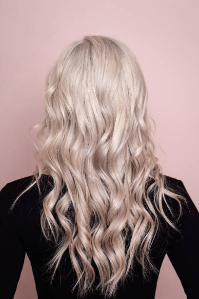 istock Female back with long, curly, blonde hair 1412021928