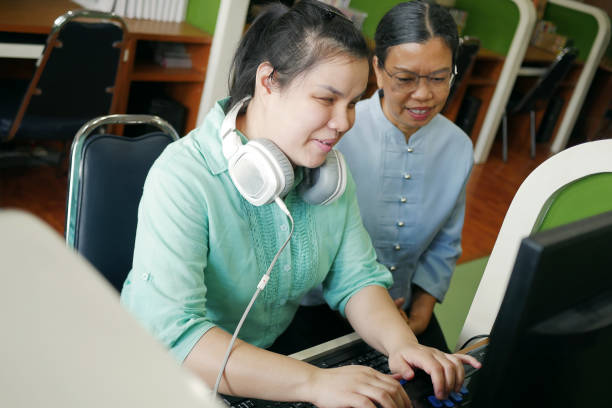 istock Asian women co-workers in office workplace including person with blindness disability using computer with refreshable braille display assistive device. Disability inclusion at work concepts. 1412027679
