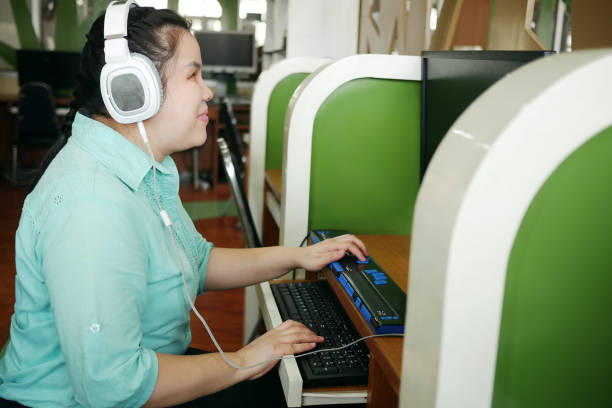 азиатская женщина со слепотой инвалидностью использует компьютер с обновляемым дисплеем брайля или терминал брайля технологию вспомогат� - accessibility стоковые фото и изображения