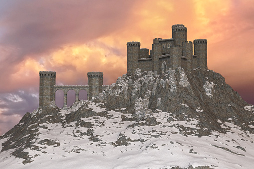Feudal castle in winter with a sunset behind it.