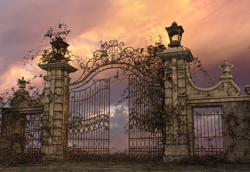 Peaceful cemetery gates with a sunset in the background.