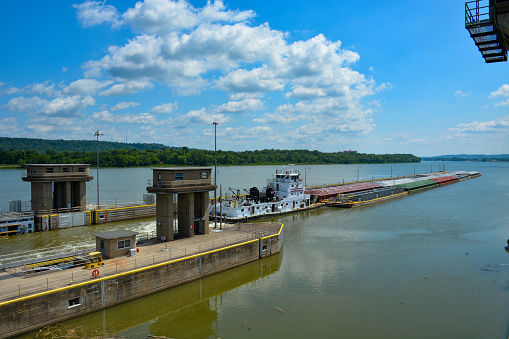 Gallatin County, Kentucky, 2022:  A tugboat and its cargo leaves the locks and Markland Lock and Dam.