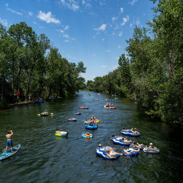 Rafters and innertubes float down the Boise River Boise, Idaho, USA – July 16, 2022: Boise Idaho popular past time of floating the river boise river stock pictures, royalty-free photos & images