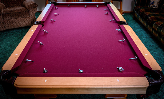 Bolts from pool table rails removed and displayed on the felt
