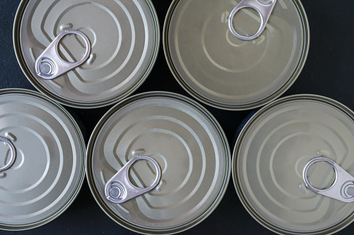 Set of different kinds of tin cans with canned food top view.