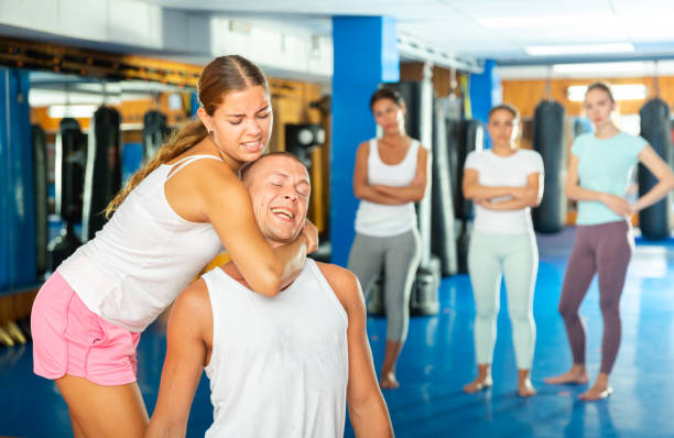 Woman makes a choke hold in self-defense training Stock Photo