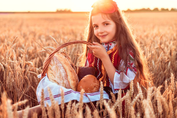 mulher búlgara ou jovem em vestido folclore tradicional segura em mãos trigo dourado e pão caseiro recém-assado em um saco - bread food baked 7 grain bread - fotografias e filmes do acervo