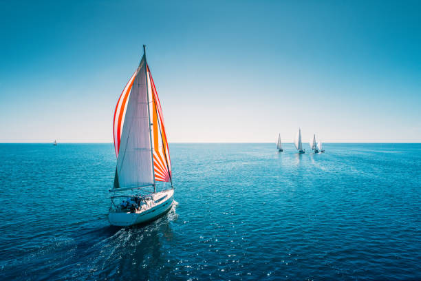 yacht a vela regata con vele bianche in mare aperto. vista aerea della barca a vela in condizioni di vento - barca a vela foto e immagini stock