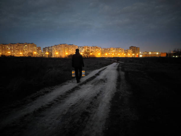 A man in the dark carries water home
