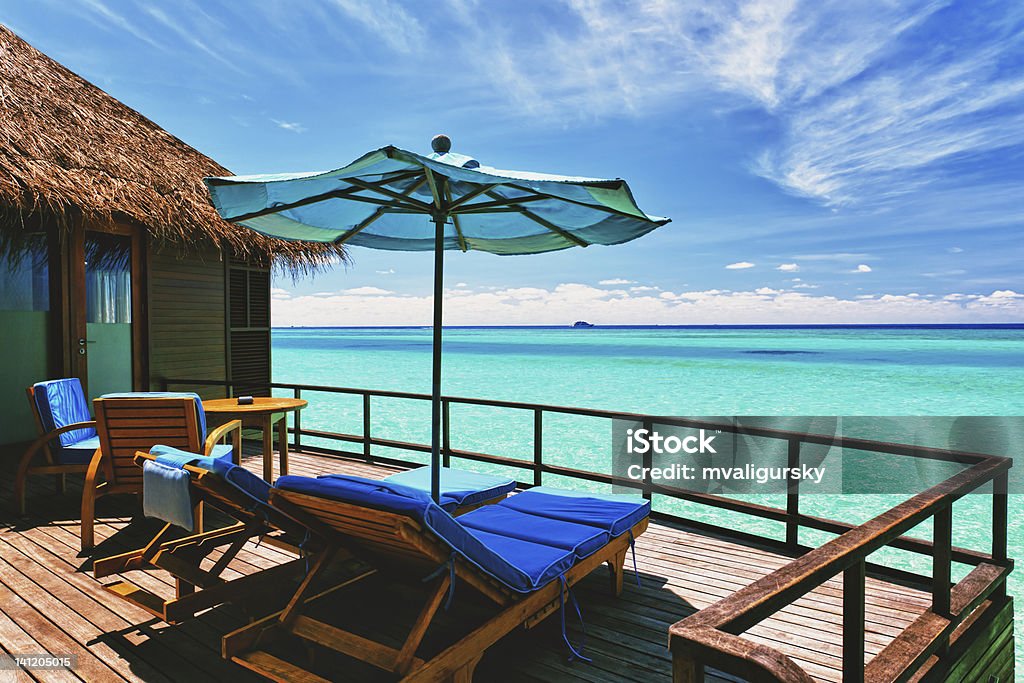 Overwater villa balcony overlooking tropical lagoon Overwater villa balcony overlooking green tropical lagoon Maldives Stock Photo