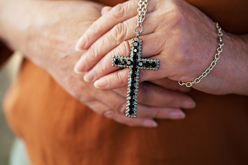 Senior woman holding a religious cross