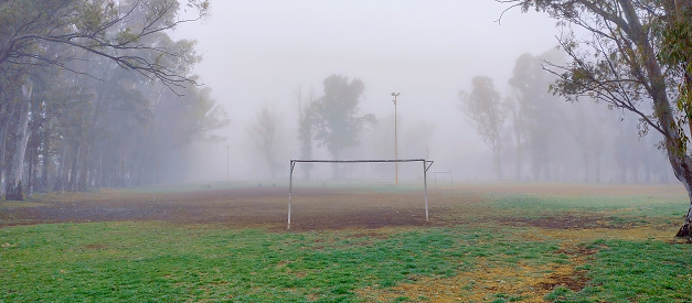 Amateur soccer field in a lonely public park in the middle of the fog. copy-space