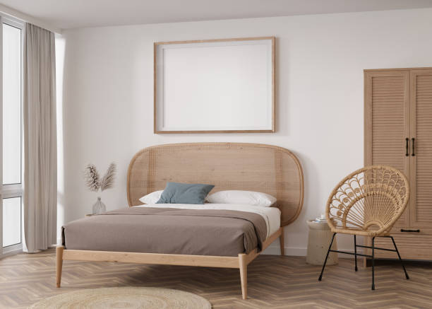 istock Empty horizontal picture frame on white wall in modern bedroom. Mock up interior in boho style. Free, copy space for your picture, poster. Bed, rattan armchair, pampas grass. 3D rendering. 1412055687