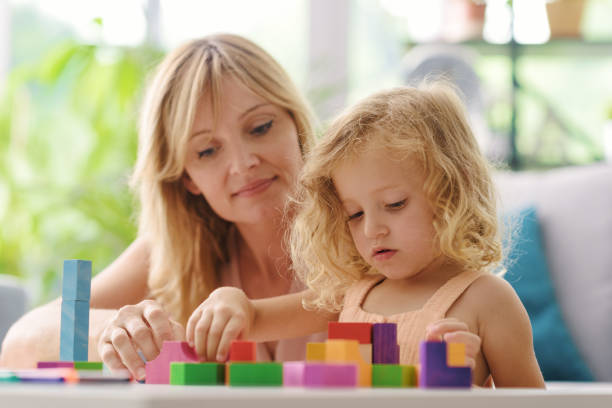 istock Happy woman playing with her daughter at home 1412057536