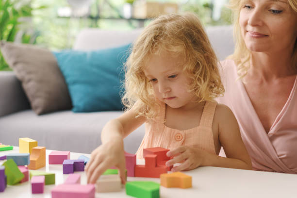 istock Happy woman playing with her daughter at home 1412059082