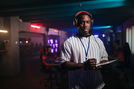 African american official during an esports competition posing for pictures while standing still.