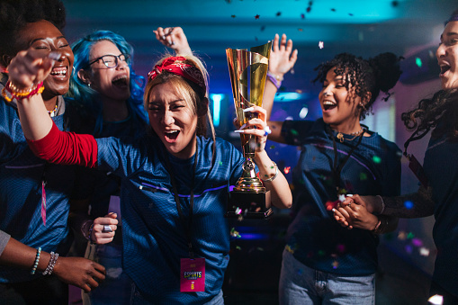 Enthusiastic girls celebrate the victory and the first place in the esport tournament