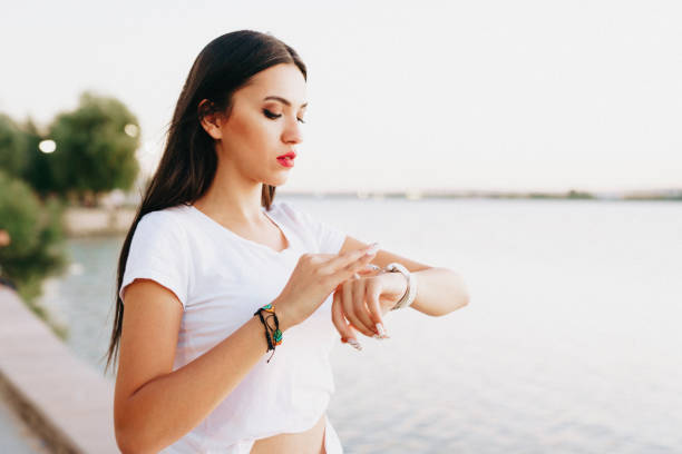 young woman looking at her smart watch stock photo