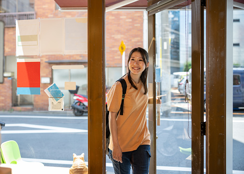 Japanese woman entering sports gym - opening the entrance door