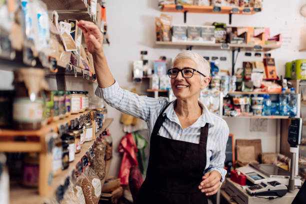 Portrait of a senior saleswoman working at her reopened store stock photo