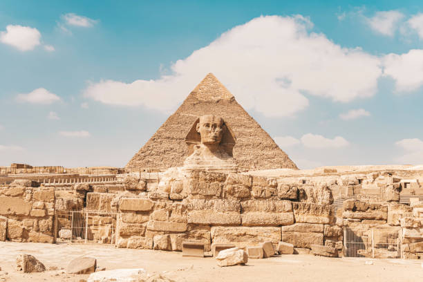 blick auf die große sphinx und die pyramiden in gizeh im hintergrund an einem wunderschönen bewölkten blauen himmelstag - great pyramid stock-fotos und bilder