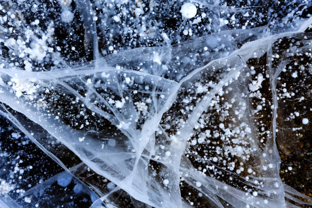 bulles de méthane dans la glace du baïkal. fissures à la surface du lac. - crystallization photos et images de collection