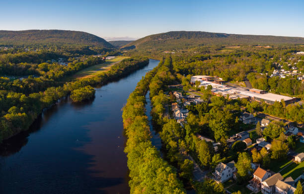 Historic Lehigh Canal was used for a coal transportation along with the Lehigh River near Slatington, PA. The hot air balloon is preparing for take-off from the rural airport in the backdrop. Aerial scenic view of the small American town Slatington lying along with the Lehigh River and historical Lehigh Chanel used for coal transportation, Lehigh Valley, Pennsylvania, USA, on a sunny evening in the early autumn. the poconos stock pictures, royalty-free photos & images