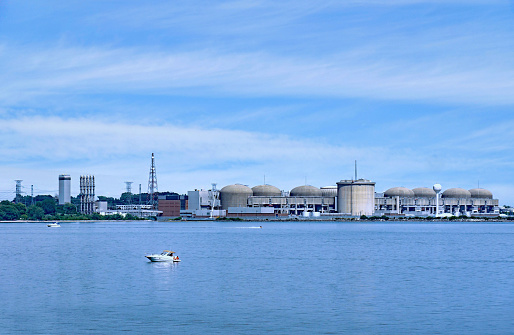Ontario, Canada - July 31, 2022:  Boaters on Lake Ontario enjoy a summer day in front of the Pickering Nuclear Power Generating station in the Toronto area