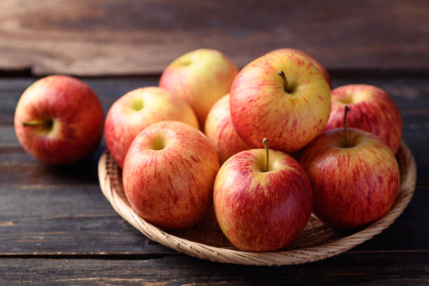 istock Red apple fruit in basket on wooden background 1412107731