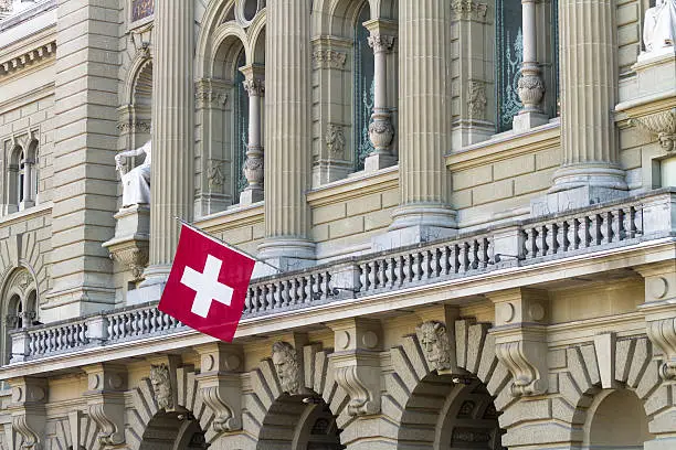 Bundeshaus Facade with Swiss Flag in Bern.