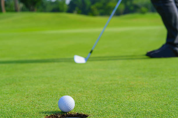 istock Golfer putt golf ball into hole on the green at golf course 1412114293