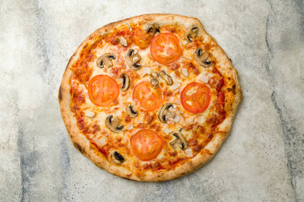 istock Pizza with chicken and mushrooms with tomatoes on stone table 1412117502