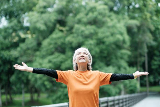 istock ic Senior woman stretch arm in park. 1412119711