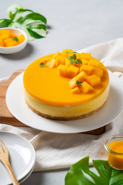 pyszne glazurowane mango bez pieczonego sernika ze świeżą pokrojoną w kostkę miazgą mango na jasnym tle stołu. - dessert cake pastry tart zdjęcia i obrazy z banku zdjęć