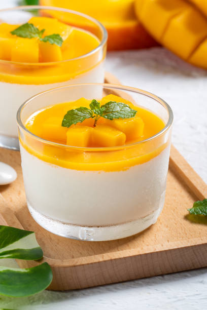 istock Delicious double colored mango panna cotta mousse pudding on white table background. 1412120360