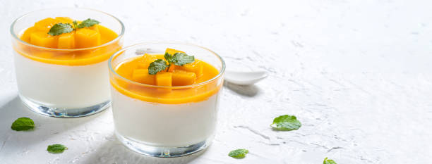 istock Delicious double colored mango panna cotta mousse pudding on white table background. 1412120438