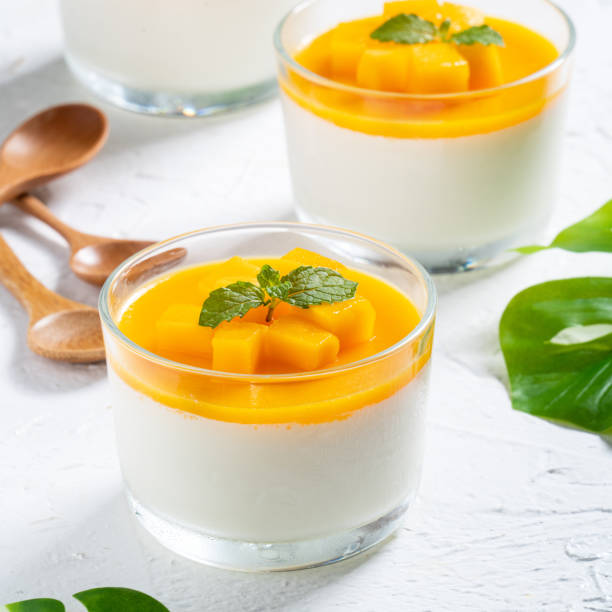 istock Delicious double colored mango panna cotta mousse pudding on white table background. 1412120971