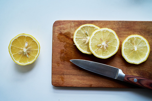 slices of lemon and kitchen knife on cutting board