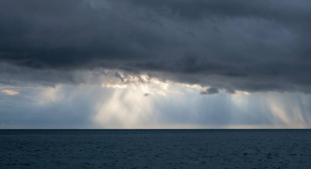 istock Storm clouds with Sun beam through heavy sky. 1412133860