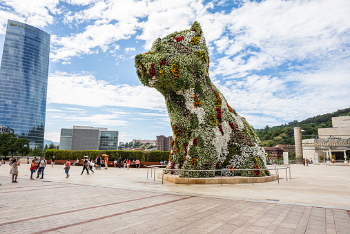 Since it opened in 1997, a guard dog known as Puppy has guarded the doors of the Guggenheim Museum in Bilbao with a changing mantle of tens of thousands of flowers. Always on guard, this West Highland white terrier, a “small” 12.4-meter-tall Scottish white furred dog about 16 tonnes in weight.