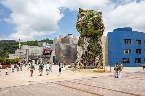 Since it opened in 1997, a guard dog known as Puppy has guarded the doors of the Guggenheim Museum in Bilbao with a changing mantle of tens of thousands of flowers. Always on guard, this West Highland white terrier, a “small” 12.4-meter-tall Scottish white furred dog about 16 tonnes in weight.